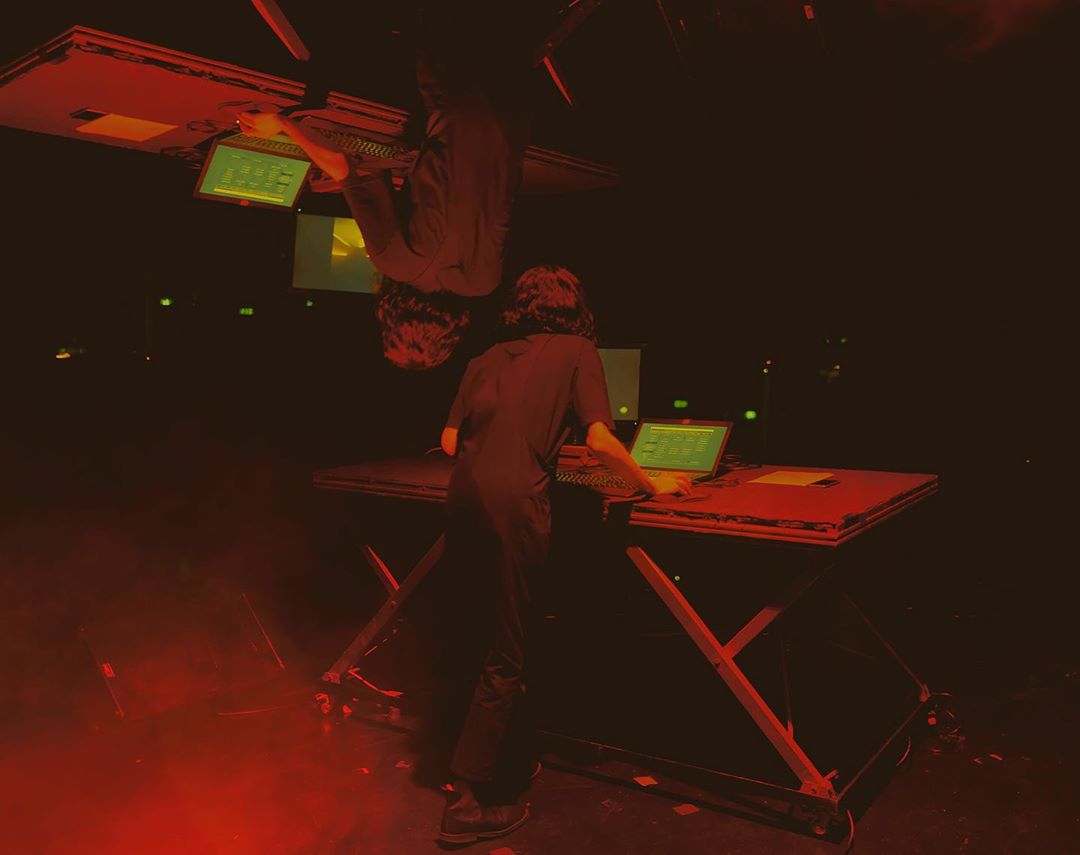 Gui performing on stage, facing the computer screen.